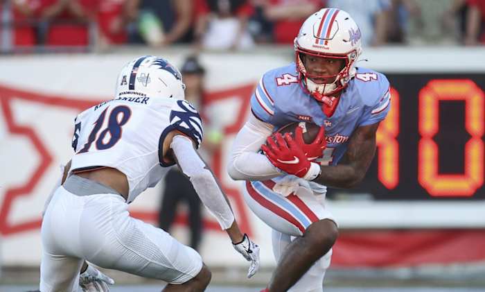Houston Cougars wide receiver Samuel Brown (4) runs with the ball after a reception as UTSA Roadrunners cornerback Kam Alexander (18) defends during the second quarter at TDECU Stadium.